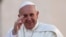 Pope Francis waves as he arrives to lead his Wednesday general audience in Saint Peter's Square at the Vatican, Sept. 18, 2013.
