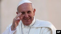 FILE - Pope Francis waves as he arrives to lead his Wednesday general audience in Saint Peter's Square at the Vatican.