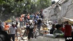 People remove debris of a collapsed building looking for possible victims after a quake rattled Mexico City, Sept. 19, 2017.