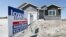 A sign sits in front of a new home for sale in West Des Moines, May 21, 2014, Iowa.
