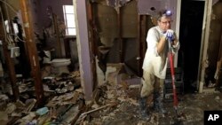 Edward Woods takes a break from cleaning up his mother's home, which was destroyed by floodwaters in the aftermath of Hurricane Harvey, Sunday, Sept. 3, 2017, in Spring, Texas.