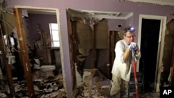 Edward Woods takes a break from cleaning up his mother's home, which was destroyed by floodwaters in the aftermath of Hurricane Harvey, Sunday, Sept. 3, 2017, in Spring, Texas.