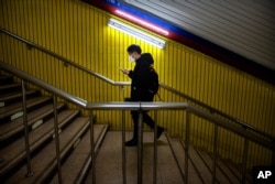 A man wearing a face mask walks through a normally busy subway station during the morning rush hour in Beijing, Feb. 3, 2020.