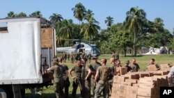 US troops load military rations into a truck headed to a local orphanage destroyed in Haiti earthquake