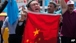 ARSIP – Foto warga Uighur yang tinggal di Turki bersama warga Turki pendukungnya meneriakkan slogan-slogan seraya mengangkat bendera China sebelum membakarnya dalam sebuah unjuk rasa di dekat konsulat China di Istanbul (foto: AP Photo/Lefteris Pitarakis, Arsip)