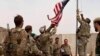 Una bandera estadounidense es bajada mientras los soldados estadounidenses y afganos asisten a una ceremonia de entrega del ejército estadounidense al ejército nacional afgano, en Camp Anthonic, Afganistán, el 2 de mayo de 2021.