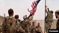 Una bandera estadounidense es bajada mientras los soldados estadounidenses y afganos asisten a una ceremonia de entrega del ejército estadounidense al ejército nacional afgano, en Camp Anthonic, en la provincia de Helmand, Afganistán, el 2 de mayo de 2021