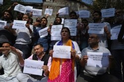 FILE - Journalists hold signs during a protest against the ongoing restrictions of the Internet and mobile phone networks at the Kashmir Press Club during a lockdown in Srinagar, Oct. 3, 2019.