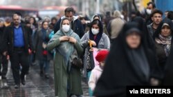 FILE - Iranian women wear masks to prevent against the coronavirus as they walk at Grand Bazaar in Tehran, Iran, Feb. 20, 2020. (West Asia News Agency/Nazanin Tabatabaee via Reuters)