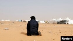 FILE - A Tunisian protester prays during a sit-in at the Kamour oilfield, demanding jobs and a share in revenue from the area's natural resources, near the town of Tatouine, Tunisia, May 11, 2017. 