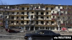 FILE - A man drives a car past a damaged building following recent shelling in the town of Shushi (Shusha), in the course of a military conflict over the breakaway region of Nagorno-Karabakh, Oct. 29, 2020. (Vahram Baghdasaryan/Photolure via Reuters)