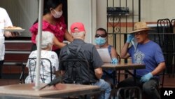 15일 미국 텍사스주 샌안토니오의 한 식당에서 마스크를 쓴 종업원과 손님들.