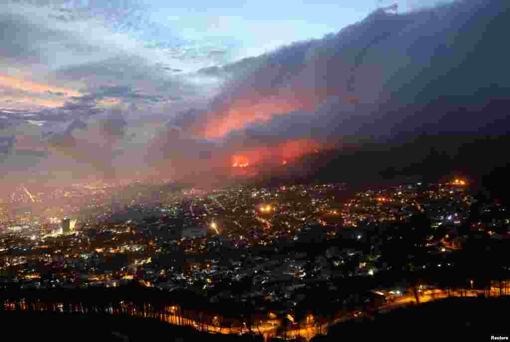 Flames are seen close to the city fanned by strong winds after a bushfire broke out on the slopes of Table Mountain in Cape Town, South Africa.