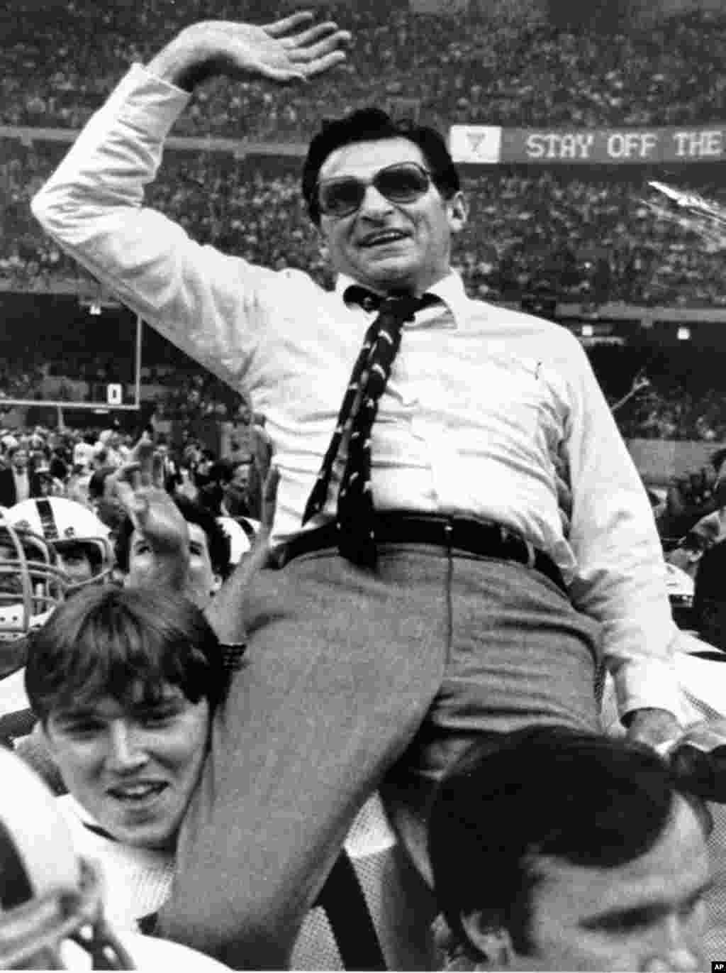 Penn State head football coach Joe Paterno waves as he gets a victory ride in the Louisiana Superdome after winning the national championship with a 27-23 win over Georgia in the Sugar Bowl in New Orleans, January 1, 1983. (AP)