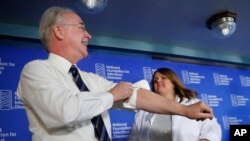 Health and Human Services Secretary Tom Price (L) rolls-up his sleeve before receiving a flu shot from Sharon Walsh-Bonadies, RN. (R), during a news conference in Washington, Sept. 28, 2017.