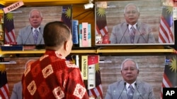 A customer watches a live broadcast of an announcement by Malaysian Prime Minister Najib Razak in Kuala Lumpur, Malaysia, April 6, 2018. 