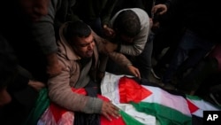 FILE - Palestinians mourn relatives killed in an Israeli bombardment of the Gaza Strip, at Al-Aqsa Martyrs Hospital in Deir al-Balah, Jan. 5, 2025. The case against an Israeli soldier in Brazil is raising the prospect that Israeli troops could face prosecution abroad.