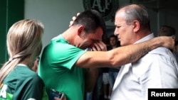 Chapecoense goalkeeper Jose Nivaldo, left, reacts as he talks with Jose Tozzi, who became the team's acting president when his predecessor died in the crash in Chapeco, Brazil, Nov. 30, 2016.