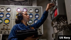 سەربازێکی بەشی تەکنیکی پشکنینی سەلامەتی ئامێرەکانی کەشتی فڕۆکە هەڵگری ئەبراهام لینکن دەکات