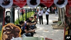 FILE - Indians use their mobile phones in New Delhi, India, Sept. 22, 2015. The government wants social media users monitored and fake news identified.