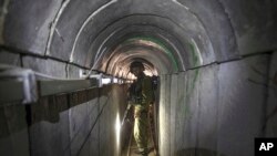 FILE — An Israeli army officer gives journalists a tour of a tunnel allegedly used by Hamas for cross-border attacks, at the Israel-Gaza Border July 25, 2014.