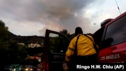 Seorang petugas pemadam kebakaran memperhatikan kebakaran hutan di kawasan Pacific Palisades, Los Angeles, Minggu, 16 Mei 2021. (Foto: Ringo H.W. Chiu/AP)