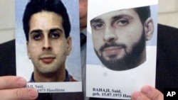 FILE - An employee of the German Federal Police holds up two handouts photos depicting Said Bahaji, also known as Zuhair al-Maghribi, with and without beard, during a press briefing in Karlsruhe, Germany, Sept. 21, 2001.