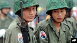 Two young Karen soldiers guard his jungle camp of Mi Aye Bo in Burma's Karen state near the Thai border during a Karen New Year celebration, December 23, 2003. 