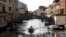 A bridge that once separated the Venice ghetto (L) from Catholic Venice (R) is seen as a boat passes northern Italy, March 22, 2016. 