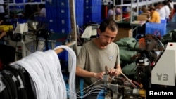 2026년 4월 2일 중국 광둥성 둥관의 한 플라스틱 부품 공장에서 직원이 USB 케이블 생산 작업을 하고 있다.