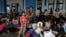 FILE - A Venezuelan migrant woman poses for a picture with her children, while they wait to have their documents processed at the Ecuador-Peru border, on the outskirts of Tumbes, Peru, June 17, 2019.