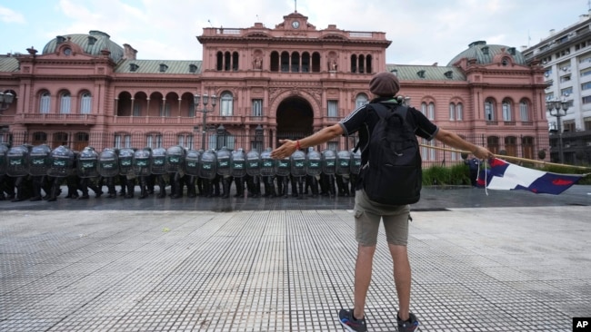 Un manifestante se enfrenta a la policía que custodia el palacio presidencial durante una protesta contra el gobierno de Javier Milei, en Buenos Aires, Argentina, el miércoles 12 de marzo de 2025.