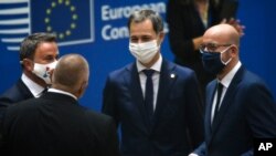 Luxembourg's PM Xavier Bettel, left, speaks with European Council President Charles Michel, right, and Greek PM Kyriakos Mitsotakis, center, during a round table meeting at an EU summit at the European Council building in Brussels, Oct. 1, 2020. 