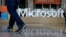 FILE - A man walks past a Microsoft sign set up for the Microsoft BUILD conference at Moscone Center in San Francisco, April 28, 2015. Microsoft says it’s requiring its U.S. suppliers to offer their employees at least 12 weeks paid leave to care for a new