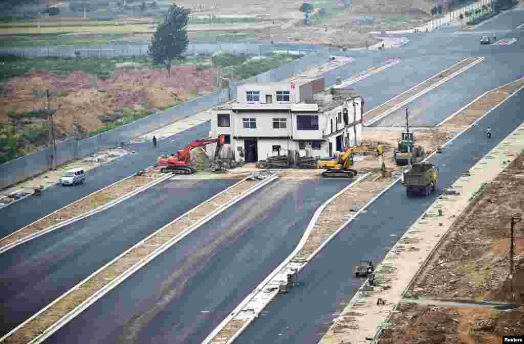 A three-story &#39;nail house&#39;, the last building in the area, with a Chinese national flag on its rooftop is seen in the middle of a newly built road in Luoyang, Henan province, China. According to local media, the house owner did not agree with government&#39;s compensation plan for relocation and refused to move out.