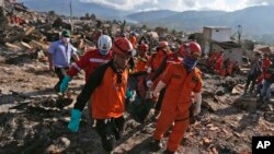 Tim SAR mengangkat mayat korban di desa Balaroa, daerah paling parah terdampak gempa bumi di Palu, Sulawesi Tengah, 8 Oktober 2018. 