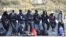 FILE - Young migrants wait to board a bus leaving for a reception centre, in Calais, on Oct. 28, 2016, following a massive operation to clear the "Jungle" migrant camp.