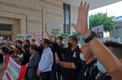 El magnate de los medios de comunicación de Hong Kong, Jimmy Lai, tercero de la derecha, grita eslóganes con activistas pro-democracia ante un tribunal por cargos relacionados con las protestas ilegales del año pasado, el lunes 15 de junio de 2020.