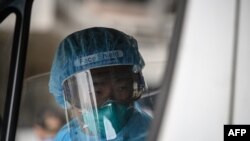 An ambulance driver, wearing protective clothing is pictured after arriving at Princess Margaret Hospital in Hong Kong on Jan. 26, 2020. 