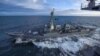 El destructor USS Kidd navega junto al portaaviones USS Theodore Roosevelt durante maniobras militares en el golfo de Alaska, el 16 de mayo de 2019. En estos momentos, ambas naves permanecen en puerto debido al nuevo coronavirus.