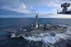 FILE - The U.S. Navy Arleigh Burke-class guided-missile destroyer USS Kidd transits alongside the aircraft carrier USS Theodore Roosevelt while participating in Exercise Northern Edge 2019 in the Gulf of Alaska, May 16, 2019.