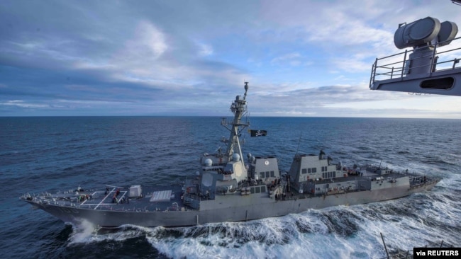 资料照片:美国海军"基德号"导弹驱逐舰在阿拉斯加湾参加演习时与"西奥多·罗斯福号”航空母舰并肩行驶。(2018年5月16日)
