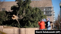 Warga setempat tampak mengamati pohon yang tumbang akibat angin kencang yang melanda wilayah metropolitan Denver, Colorado, pada 15 Desember 2021. (Foto: AP/David Zalubowski)