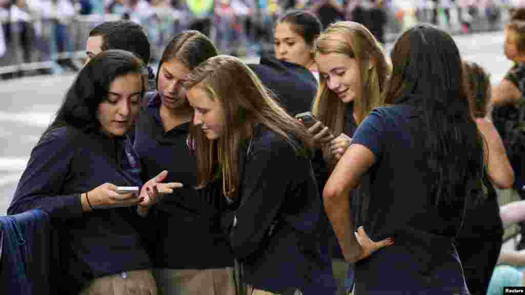 A group of Catholic school girls look at their phones as they wait on the route that Pope Francis will take later in the day near St. Patrick&rsquo;s Cathedral in New York September 24, 2015.