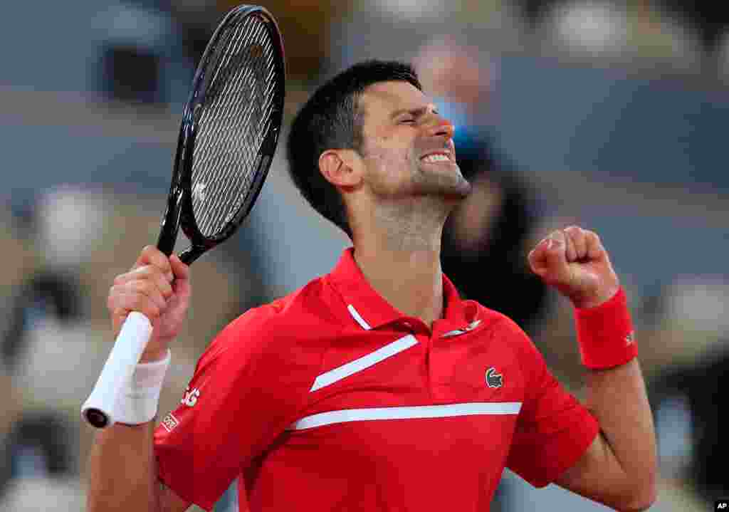 Serbia&#39;s Novak Djokovic celebrates winning his fourth round match of the French Open tennis tournament against Russia&#39;s Karen Khachanov in three sets 6-4, 6-3, 6-3, at the Roland Garros stadium in Paris, France.