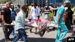 Petugas SAR dari Somalia dan Turki membawa seorang perempuan yang terluka dalam serangan bom di Mogadishu, Somalia pada 28 Desember 2019. Korban dievakuasi ke Turki dari Bandara Adan Adde untuk perawatan medis lebih lanjut, 29 Desember 2019. (Foto: AFP)