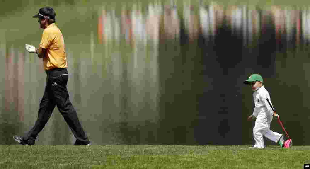 Bubba Watson walks with his son Caleb during the Par 3 contest at the Masters golf tournament in Augusta, Georgia, USA, April 8, 2015. (AP Photo/Matt Slocum)