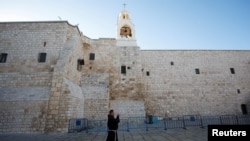 Seseorang berjalan di Gereja Kelahiran menjelang kedatangan Patriark Latin Yerusalem, Pierbattista Pizzaballa, di Betlehem di Tepi Barat yang diduduki Israel 24 Desember 2024. (Mohammed Torokman/REUTERS)