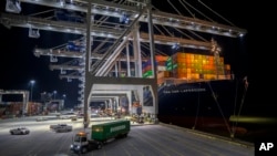 Five ship to shore cranes and gangs of longshoremen work to load and unload the container ship CMA CGM Laperouse at the Georgia Ports Authority's Port of Savannah, Sept. 29, 2021, in Savannah, Georgia.