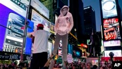 Potongan gambar Trayvon Martin dibawa para pendukungnya dalam aksi protes di Times Square, New York, Minggu (14/7), seusai diumumkannya putusan dewan juri pengadilan Florida tentang pembebasan George Zimmerman. 